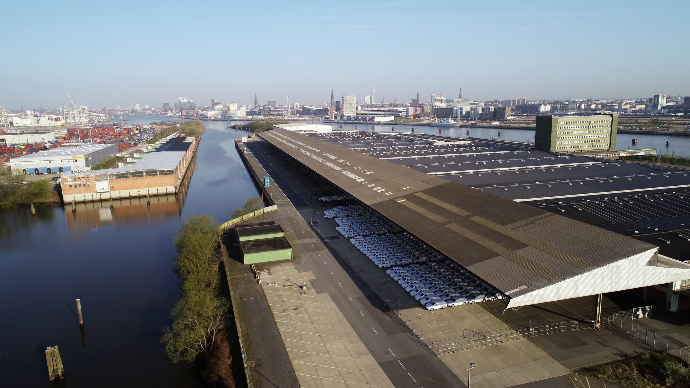 Das Überseezentrum aus der Vogelperspektive. Zentral fließt die Elbe und man sieht alte Lagerhäuser