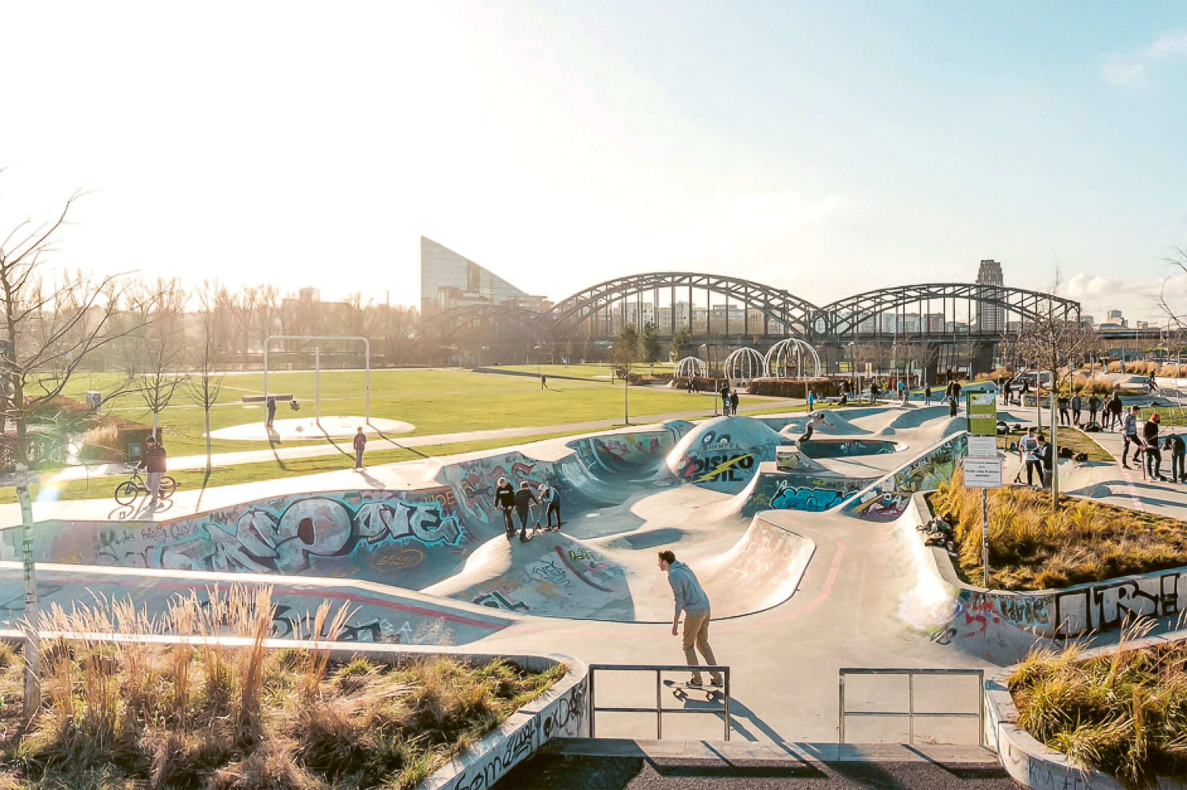 Visualisierung: Genutzter Skatepark neben einer großen Grünfläche. Dahinter liegen die Elbbrücken